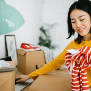 Female young small business owner selling clothes online while working at home.