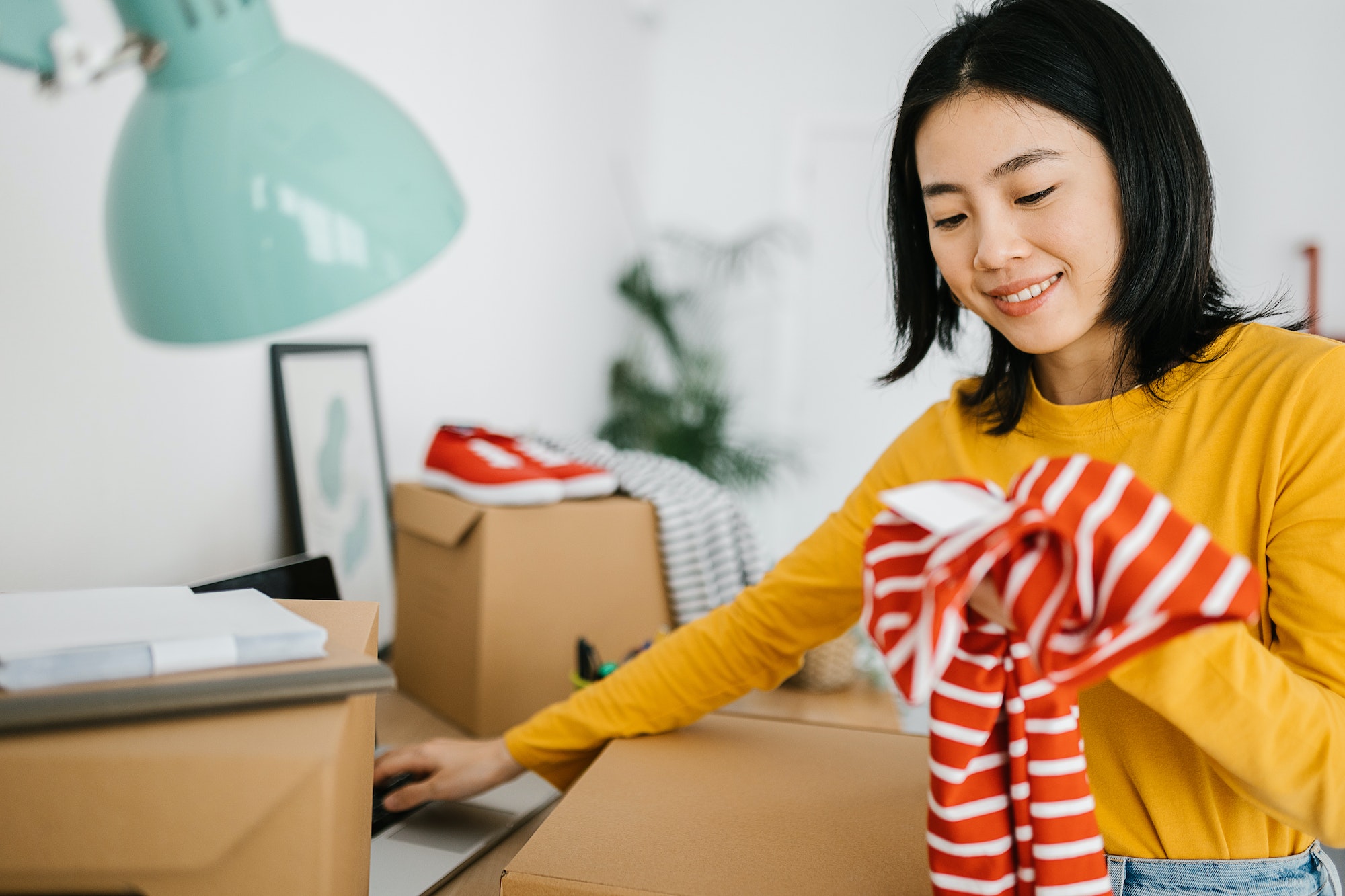 Female young small business owner selling clothes online while working at home.