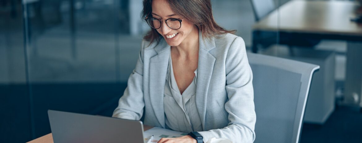 Smiling business lady working on laptop in the corporate company at modern office
